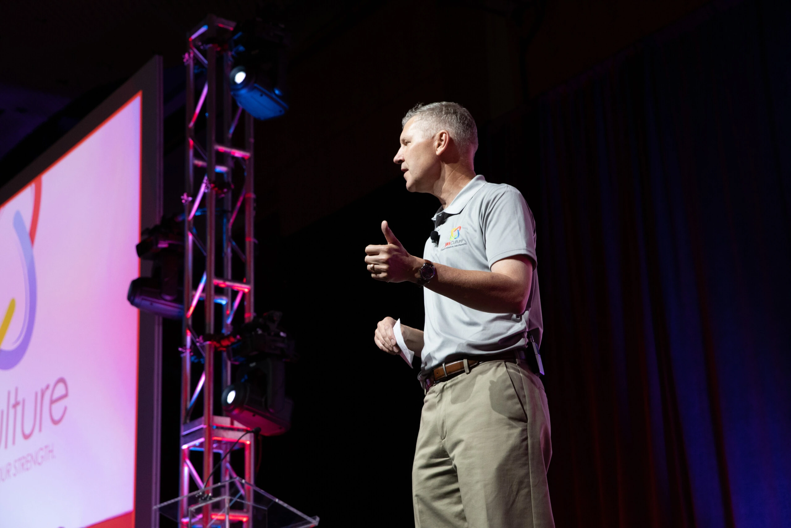 Tim Schellpeper speaking on stage at a JBS event