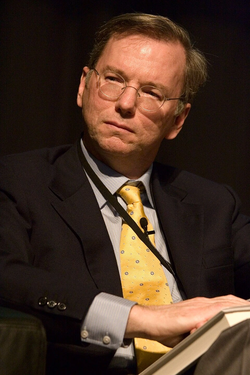 Portrait photo of Eric Schmidt seated in a suit and yellow tie